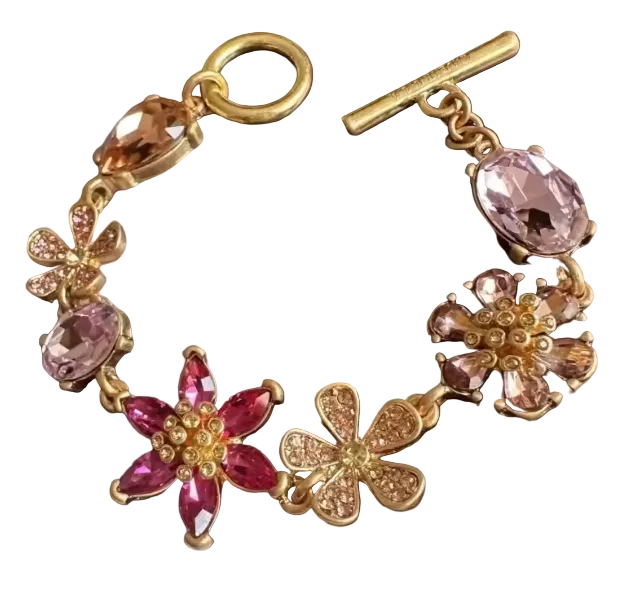 Gold bracelet with pink gemstones on a dark surface